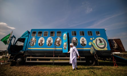 A man exits a blue horsebox decorated with the faces of former neza bazi champions
