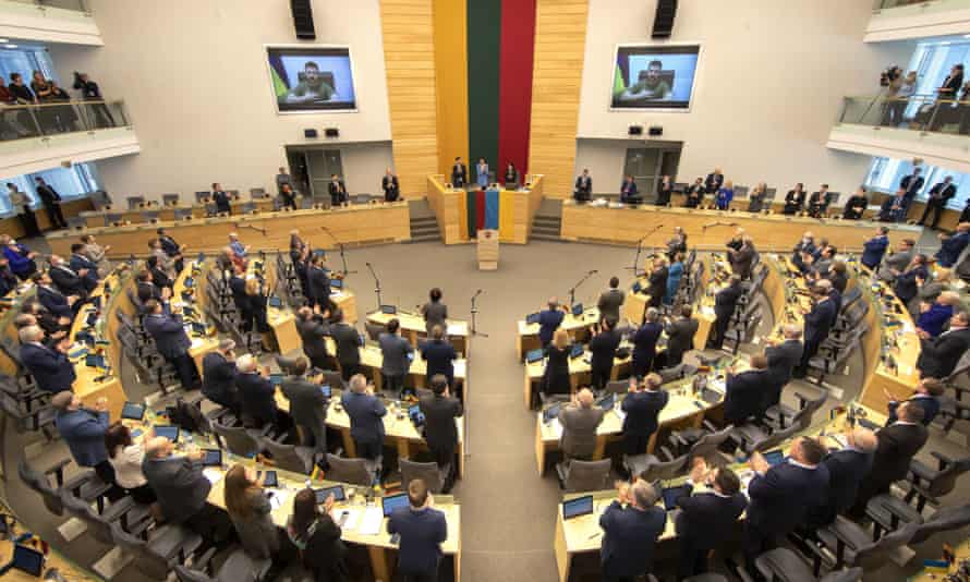 Members of Lithuanian parliament give Ukraine President Volodymyr Zelenskiy a standing ovation before he speaks in a virtual address to Lithuanian parliament in Vilnius, Lithuania, April 12, 2022.