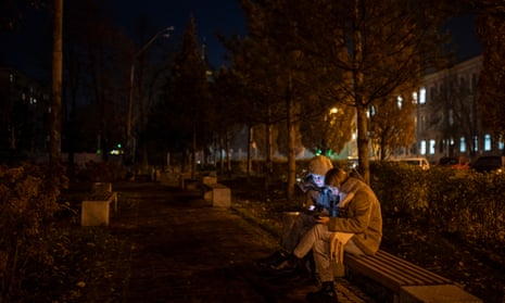 Two people look at a phone during a local power outage in Kyiv, Ukraine.