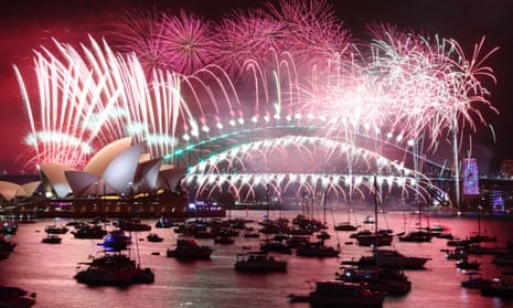 Los fuegos artificiales de Nochevieja iluminan el cielo sobre la Ópera de Sídney (L) y el puente Harbour.