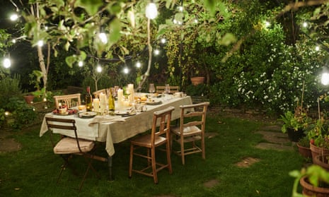 A dining table set for six people in a garden.