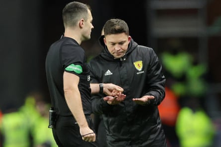 Referee Don Robertson (left) passes an object that was thrown from the crowd towards Celtic's Arne Engels to a stadium official at Ibrox in January.