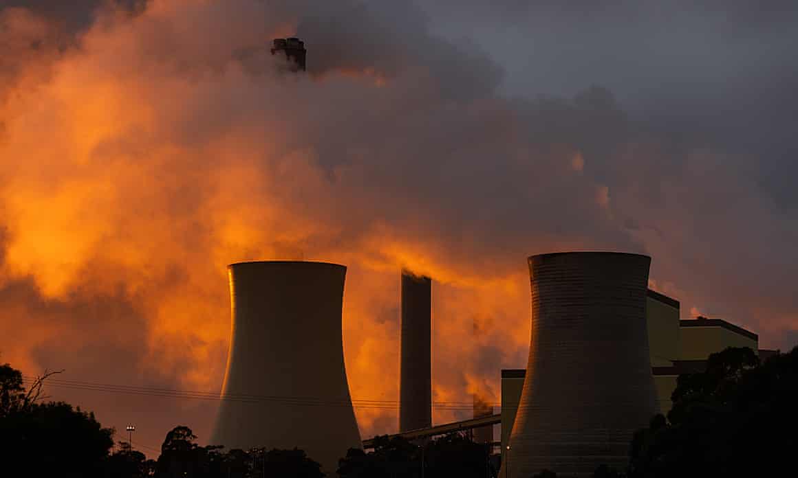 Smoke rises over cooling towers