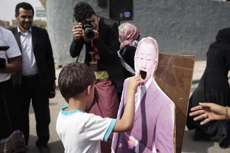 A young boy drops a Yemeni riyal into the hollowed-out mouth of a cardboard figure of then-UN secretary general Ban Ki-moon at a demonstration led by Yemeni mothers outside the UN offices in Sana’a in June 2016.