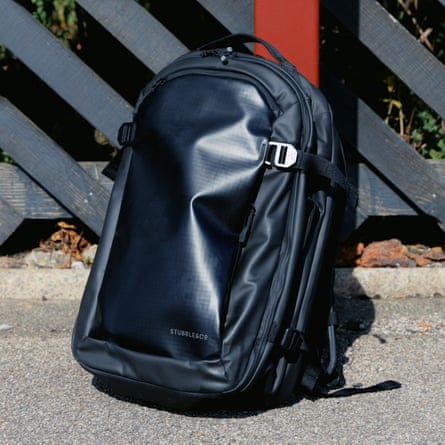 Stubble & Co Hybrid Backpack 30l on the ground in front of a grey and red fence