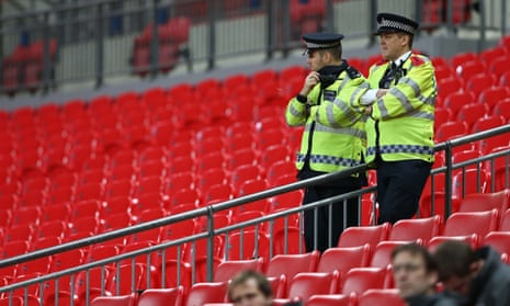British police officers stand on duty at Wembley stadium as France’s players train on the pitch ahead of their international friendly football match against England on 17 November.