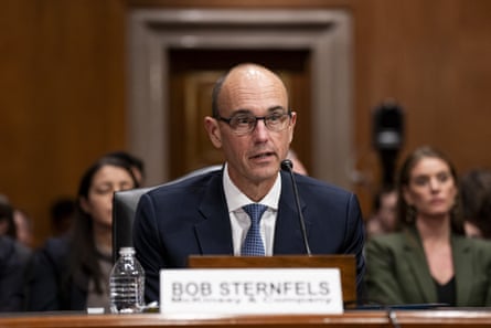 a man in front of a microphone in a hearing room
