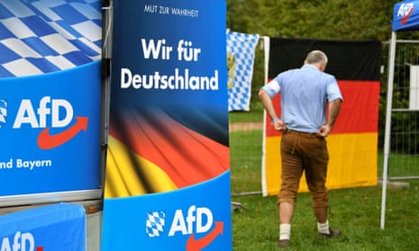 A supporter of the Alternative for Germany (AfD) walks past AfD banners at the Gillamoos Fair in Abensberg, Germany in 2019