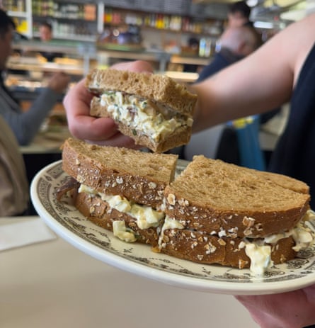 A heavily filled egg mayonnaise sandwich on brown bread, in a deli