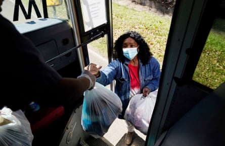 A Jefferson county school district staff member hands out several days of bagged lunches to a parent for her children on 3 March 2021 in Fayette, Mississippi.