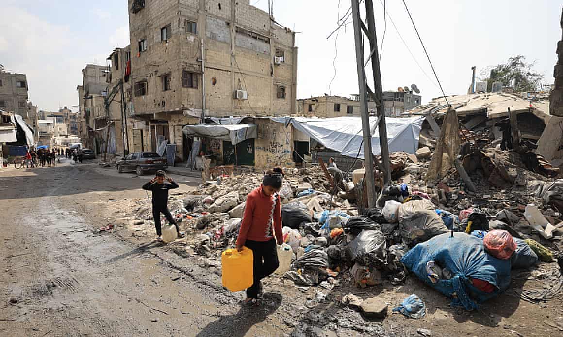 Palestinian children carrying home drums of water in eastern Gaza City