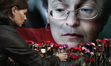 A woman places flowers before a portrait of the murdered Russian journalist Anna Politkovskaya in 2009.