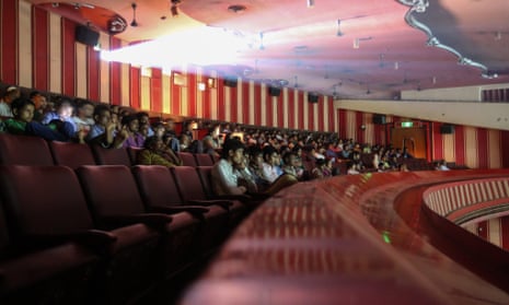 People watch a film in an Indian cinema