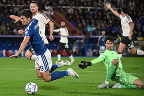 Como's Douvikas falls near the ball as Manchester United goalkeeper Lammens slides to block
