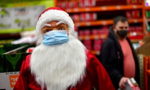 A Santa Claus figure in a face mask.