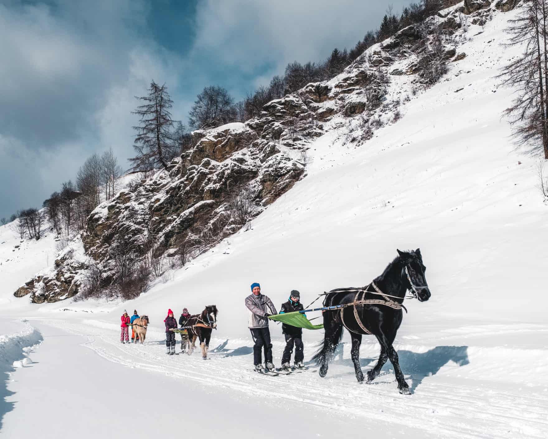 skijoring –people on skis and being pulled across the snow by a horse