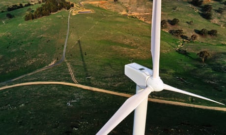 aerial view of wind turbine with green countryside below