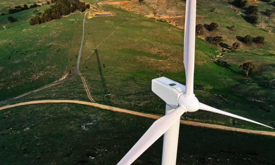 aerial view of wind turbine with green countryside below