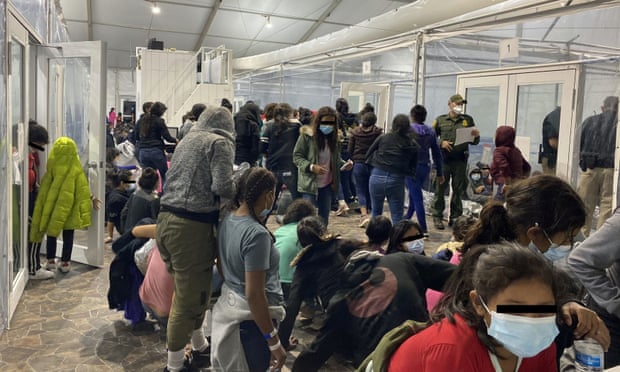 Migrants in a room with walls of plastic sheeting at a facility in Donna, Texas, in a photo released 22 March.