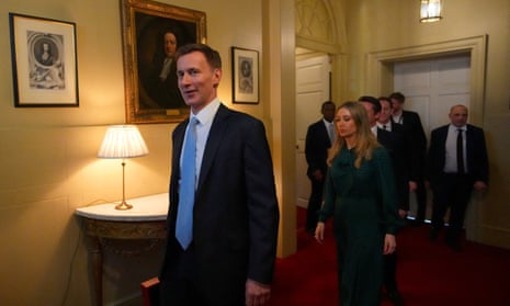 Jeremy Hunt walking through 11 Downing Street towards the door with his red box, looking at the camera and smiling