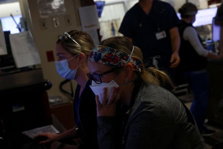 Medical workers wear face masks while working at computers in the emergency department.
