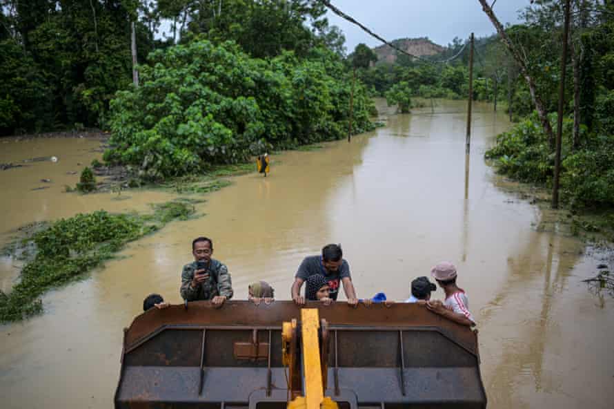 Moradores de Sementeh, perto de Lanchang, no estado de Pahang, na Malásia, são evacuados em uma escavadeira.