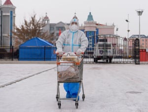 A staff member transfers materials at a residential area in Manzhouli. The second round of citywide nucleic acid testing has begun, and different procedures have been implemented to assure stable material supply.