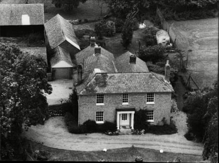 A black and white aerial image of farm buildings surrounded by trees