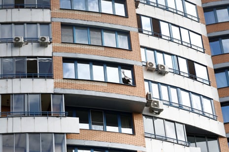 A view shows a broken window in a multi-storey apartment block apparently hit by a drone.