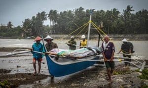 Fishermen carry a boat to higher ground in Baybay, eastern Samar, Philippines, during Typhoon Phanfone.