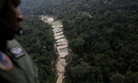 A police officer observes a disputed gold mine from an helicopter during an operation in Pará state, Brazil.