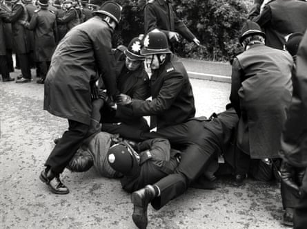 Pickets being brought to the ground by police officers.