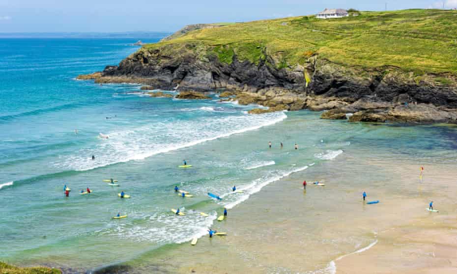 Playa de Poldhu Cove con surfistas