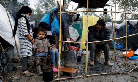 Migrants sit outside their tents at a makeshift camp for refugees and migrants next to the Moria camp, following a rainfall on the island of Lesbos, Greece.
