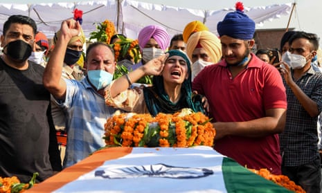 Sandeep Kaur and her brother Prabhjot Singh lay flowers on the coffin of their father, Satnam Singh, who was killed in the fight in the Galwan Valley.