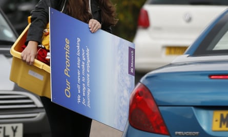 A member of Monarch Airlines cabin crew carries her personal belongings to her car at Luton
