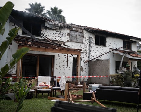 A damaged house with a partly collapsed roof and missing windows