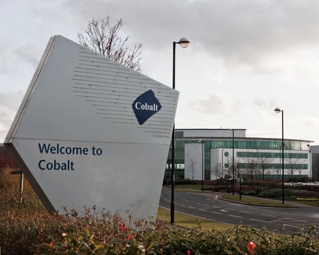 A welcome sign reading 'Welcome to Cobalt' stands in front of a modern office building under an overcast sky