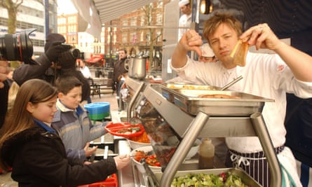 Jamie Oliver gives the thumbs down to chips and fatty food as he serves up a healthy school dinner to pupils from Ealdham Primary School