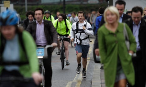 Commuters walk, use bicycles and jog on a central London bridge