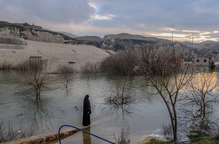 A woman stands near the ancient town of Hasankeyf, which was flooded as part of the Ilisu Dam project on the Tigris River in Turkey’s southeastern Batman province. The flooding of the area for the dam erased the original town of Hasankeyf, which stood here for 12,000 years.