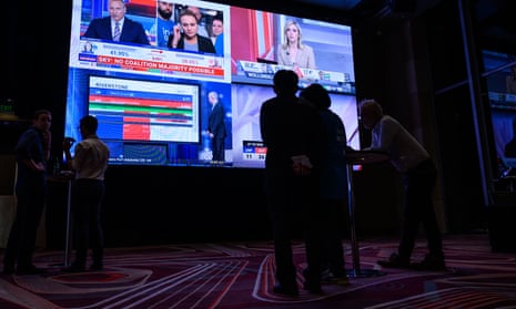 La gente mira la cobertura de noticias en un evento de la noche de las elecciones liberales de Nueva Gales del Sur