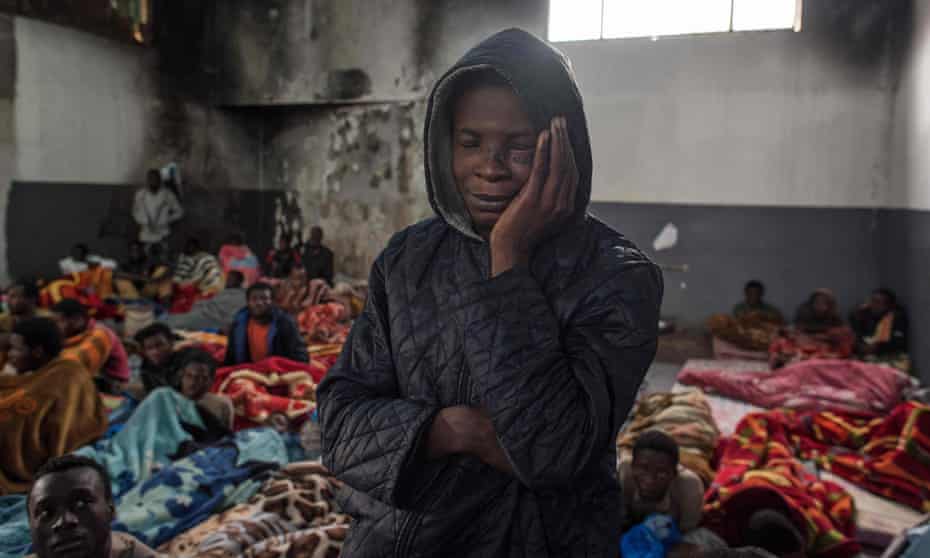 A migrant stands in a packed room at the Tariq al-Matar detention centre on the outskirts of the Libyan capital, Tripoli.