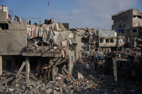 People walking through the rubble of a destroyed building.