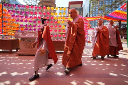Gabi and Buddhist monks pass around a pagoda during the ordination ceremony