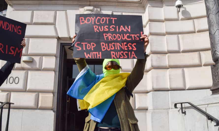 A protester extracurricular the Unilever office successful Victoria Embankment, London, holds a placard calling for a boycott of Russian products.