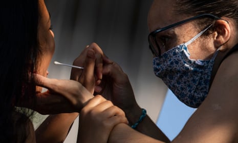 A woman administers a swab test to a girl at a Covid test site in South London.