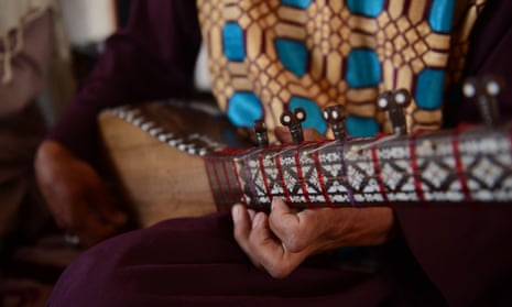 A women plays a traditional Afghan music instrument.
