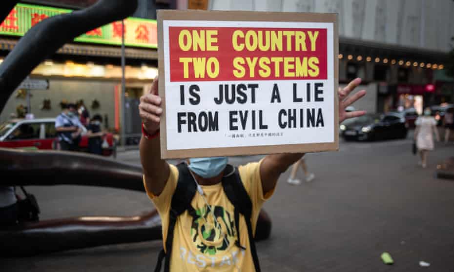 A protester in Hong Kong holds a placard on Sunday at a march that disrupted by riot police.