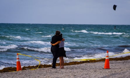 A couple hugs near the scene of the collapse in Surfside.